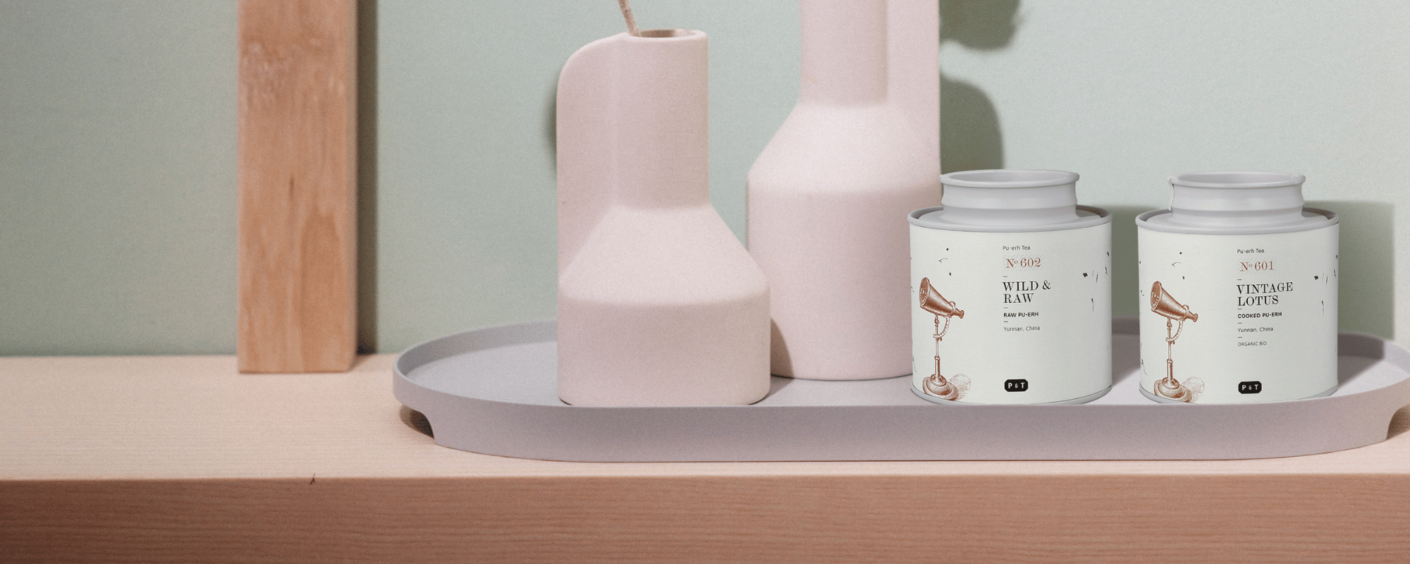 Pu Erh Tee von P&T auf einem schönen Holzregal mit Blumenvasen
