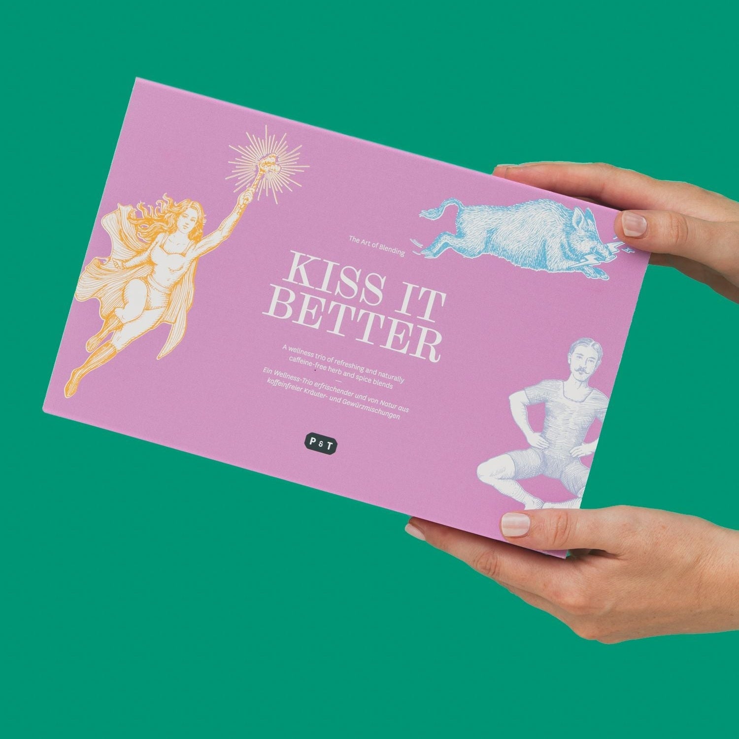 Zwei Hände halten eine violette Box mit Vintage-Illustrationen für das koffeinfreie Kräutertrio KISS IT BETTER.