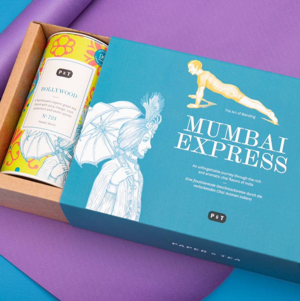 Premium-Teegeschenkset mit MUMBAI EXPRESS Teebox und BOLLYWOOD Bio-Grüntee-Dose auf blauem Hintergrund